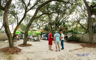 Guests visiting under the live oaks in The Courtyard at The Point Restaurant Perdido, FL
